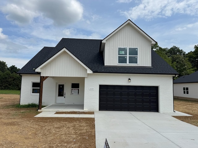 modern farmhouse style home with covered porch and a garage