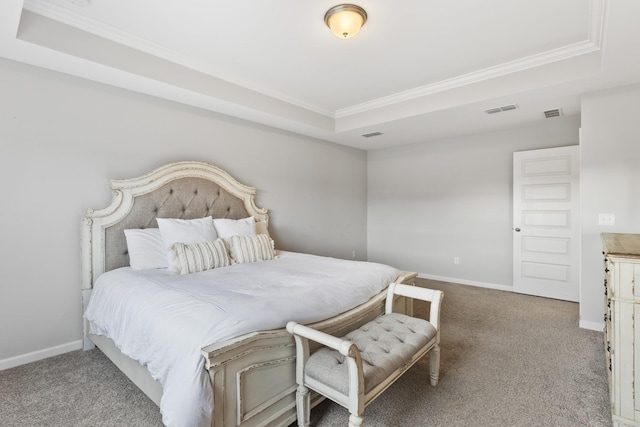 carpeted bedroom with a tray ceiling and ornamental molding