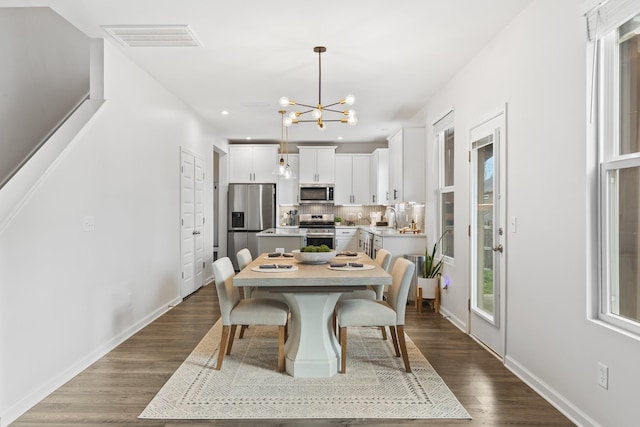 dining room featuring hardwood / wood-style flooring, a notable chandelier, and sink