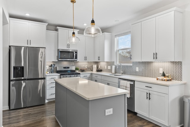 kitchen with white cabinets, decorative light fixtures, stainless steel appliances, and sink