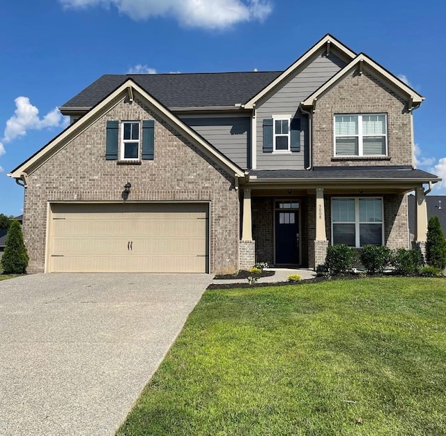 craftsman house with a front yard, concrete driveway, brick siding, and a garage