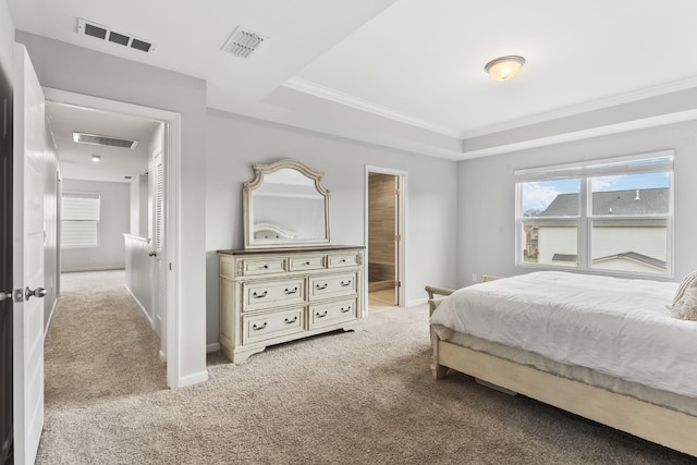 bedroom featuring crown molding, light carpet, a tray ceiling, and ensuite bath