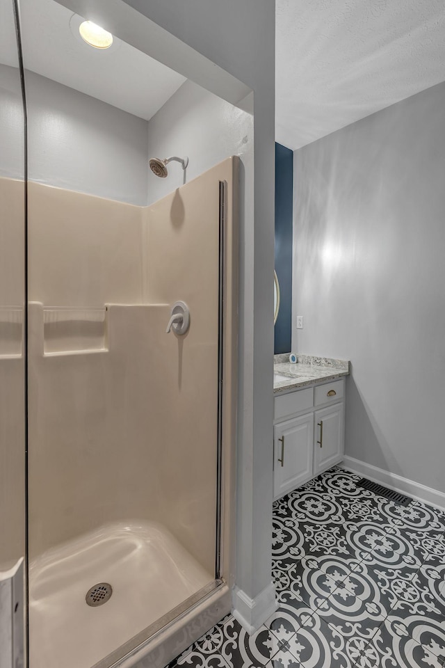 bathroom featuring vanity, tile patterned floors, and walk in shower