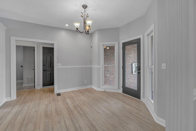 interior space with a notable chandelier and light wood-type flooring