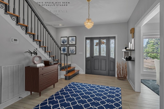 foyer with a chandelier and light hardwood / wood-style floors