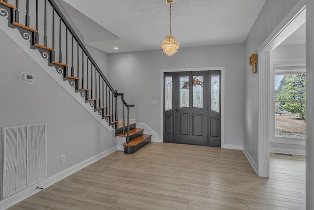 foyer with an inviting chandelier and light wood-type flooring