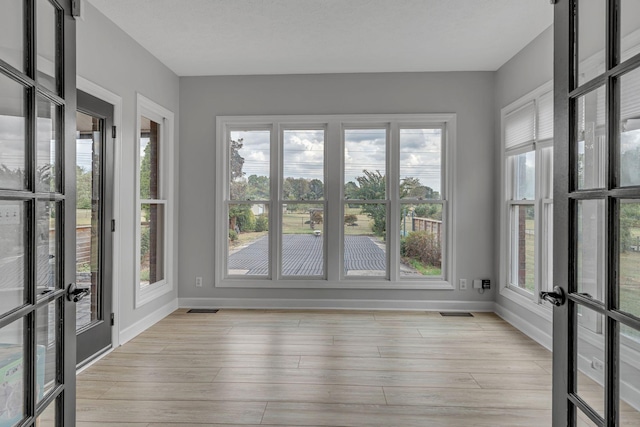 unfurnished sunroom with french doors