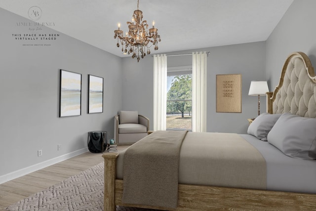 bedroom with light hardwood / wood-style floors and a notable chandelier