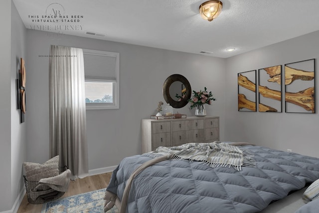 bedroom featuring light wood-type flooring and a textured ceiling