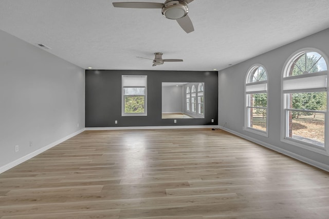 unfurnished room with a textured ceiling, light hardwood / wood-style flooring, and ceiling fan