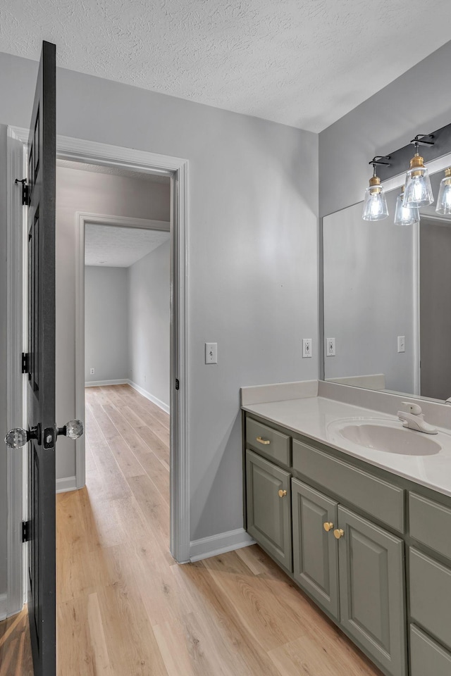 bathroom featuring vanity, hardwood / wood-style floors, and a textured ceiling