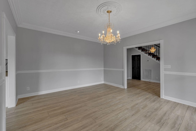 unfurnished room featuring light hardwood / wood-style floors, a chandelier, and ornamental molding