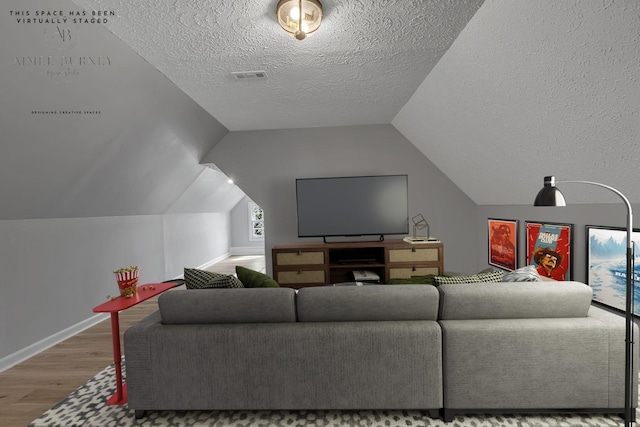 living room with hardwood / wood-style flooring, lofted ceiling, and a textured ceiling