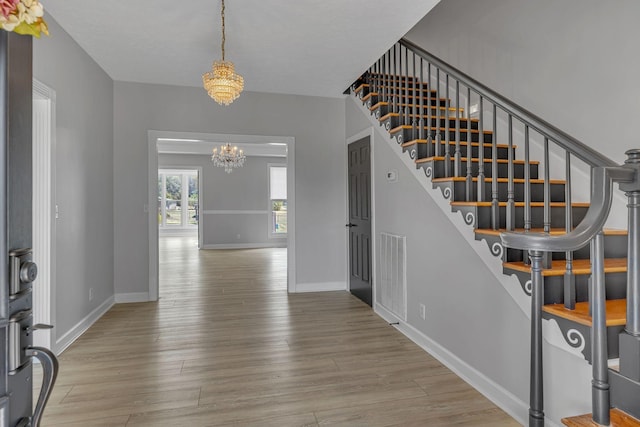 foyer featuring light hardwood / wood-style flooring and an inviting chandelier