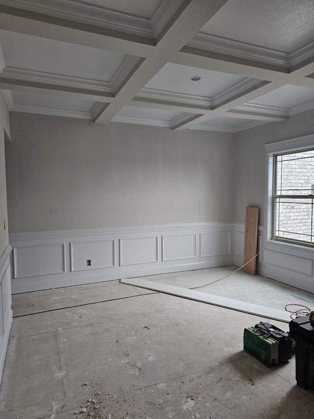 spare room featuring ornamental molding and coffered ceiling