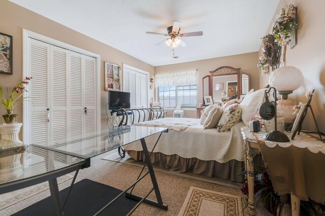 bedroom featuring carpet flooring, ceiling fan, and two closets