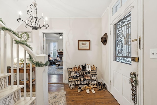 foyer entrance with dark hardwood / wood-style flooring, a notable chandelier, and ornamental molding