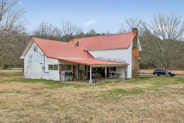 rear view of property with a lawn and a patio