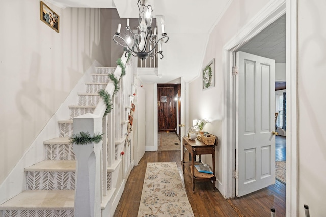 entryway featuring dark hardwood / wood-style floors, crown molding, and an inviting chandelier