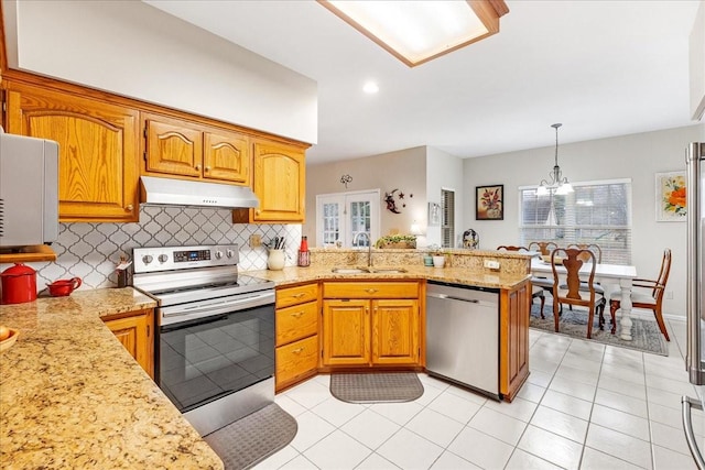 kitchen featuring sink, an inviting chandelier, kitchen peninsula, pendant lighting, and appliances with stainless steel finishes