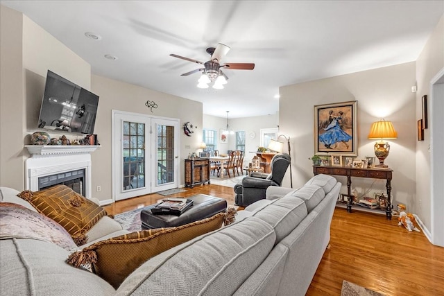 living room with ceiling fan and light hardwood / wood-style flooring