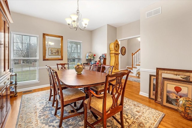 dining area featuring light wood-type flooring and an inviting chandelier