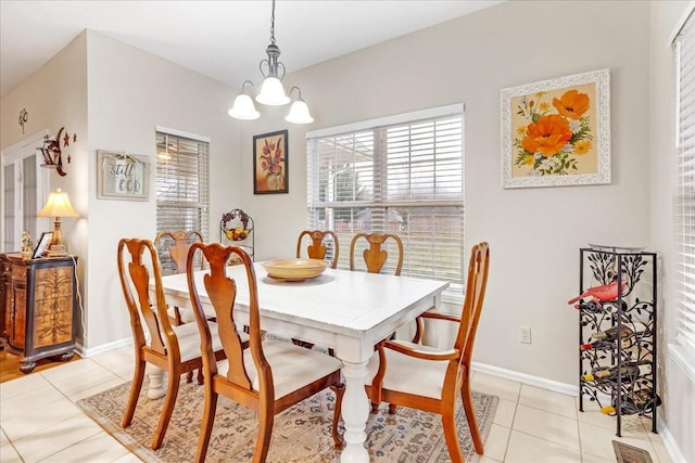 tiled dining room featuring a notable chandelier