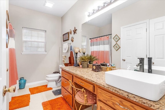 bathroom with tile patterned flooring, vanity, toilet, and walk in shower