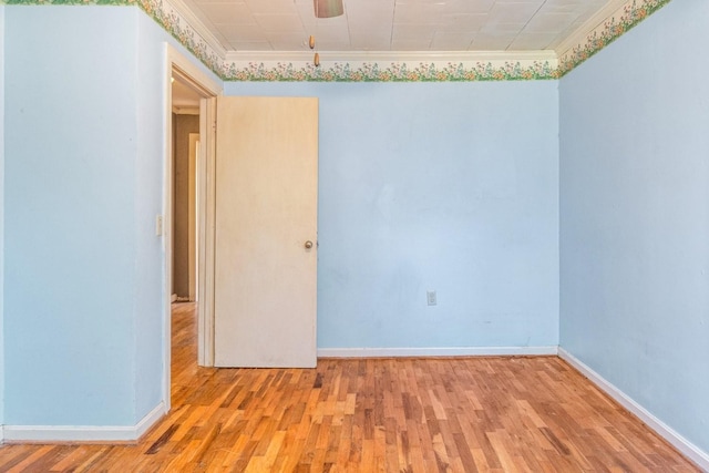 spare room with ornamental molding and light wood-type flooring