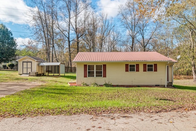 view of front of house featuring a front lawn and a storage unit