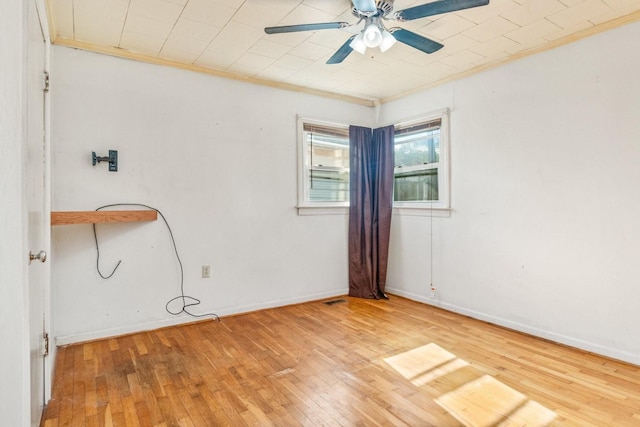 empty room featuring ceiling fan, wood-type flooring, and ornamental molding