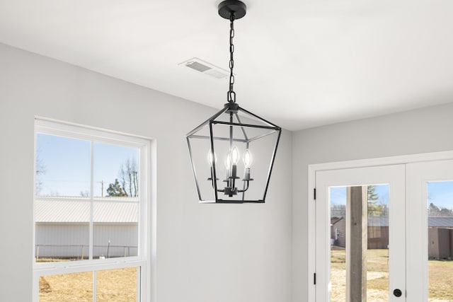 interior details with french doors and an inviting chandelier