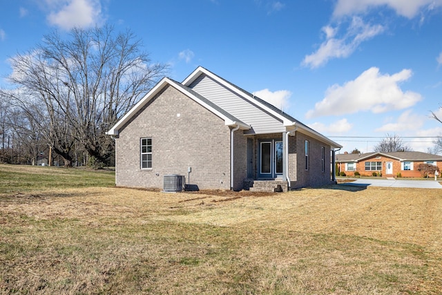 view of side of home featuring a yard and central AC unit