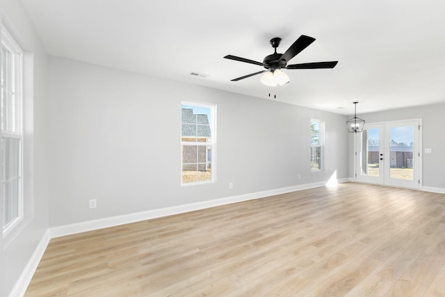 empty room featuring ceiling fan, light hardwood / wood-style floors, and french doors