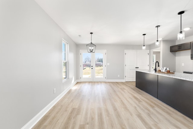 kitchen with french doors, sink, light hardwood / wood-style flooring, a chandelier, and pendant lighting