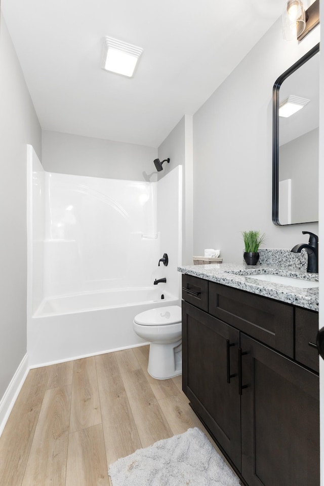 full bathroom with shower / washtub combination, vanity, wood-type flooring, and toilet