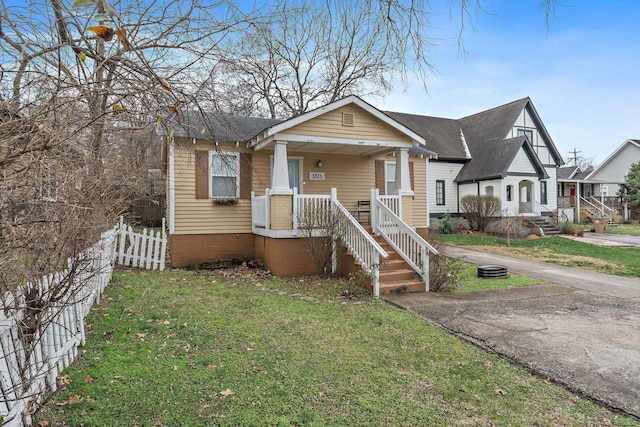 bungalow-style home featuring a porch and a front yard