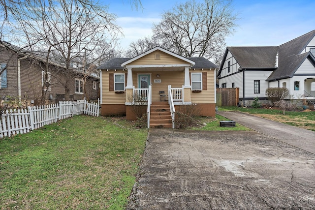 bungalow-style home with a front yard and covered porch