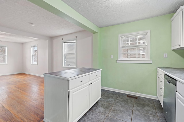 kitchen with dark hardwood / wood-style floors, tile countertops, white cabinetry, dishwasher, and a textured ceiling