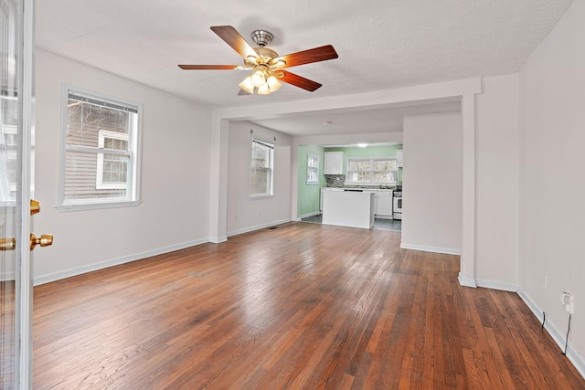 unfurnished living room with a textured ceiling, dark hardwood / wood-style floors, and ceiling fan