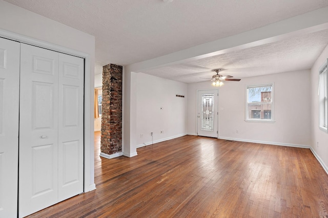 interior space featuring ceiling fan, a textured ceiling, and dark hardwood / wood-style flooring