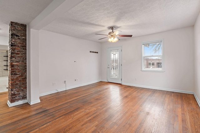 spare room with ceiling fan, dark wood-type flooring, and a textured ceiling