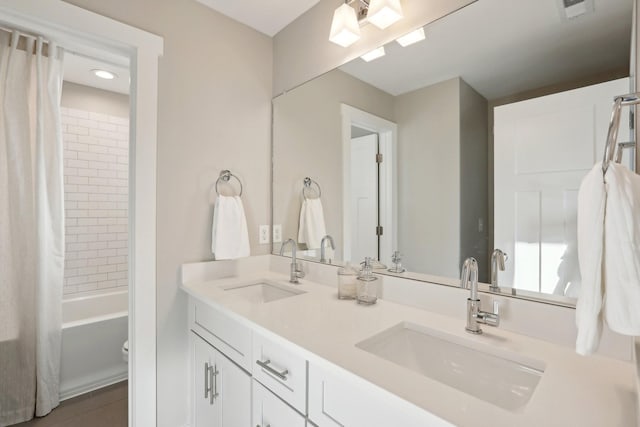 full bathroom with shower / bath combo with shower curtain, vanity, and toilet