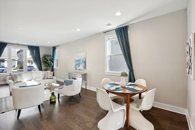 dining space featuring a wealth of natural light and dark hardwood / wood-style flooring