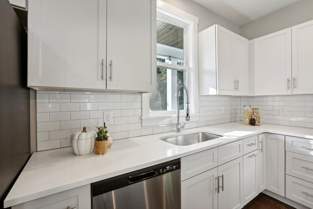 kitchen featuring decorative backsplash, sink, white cabinets, and stainless steel dishwasher