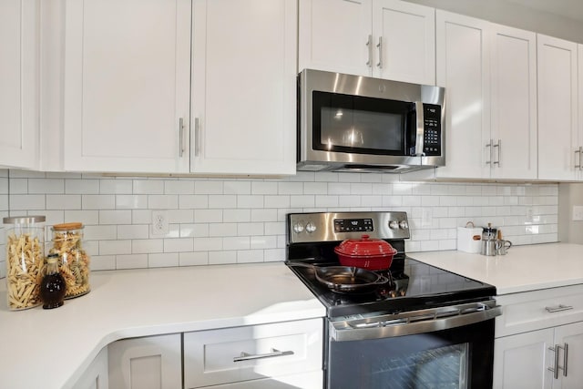 kitchen featuring decorative backsplash, white cabinets, and stainless steel appliances