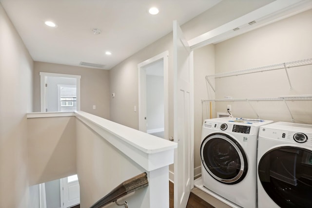 laundry room with dark hardwood / wood-style flooring and washing machine and clothes dryer