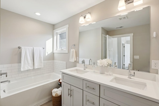 bathroom with a tub to relax in and vanity