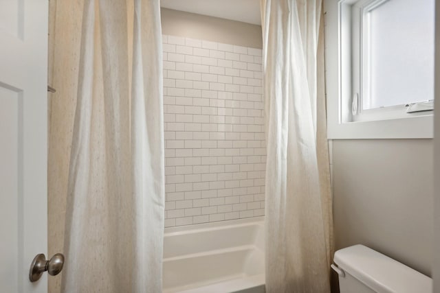 bathroom featuring toilet, shower / tub combo with curtain, and a healthy amount of sunlight