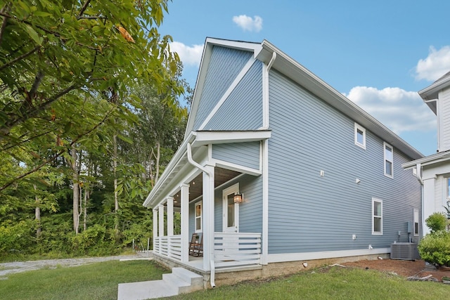 view of home's exterior featuring covered porch, a yard, and central AC